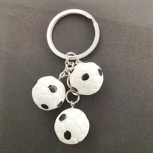 Detail of three mini resin soccer ball pendants attached to a silver metal keychain