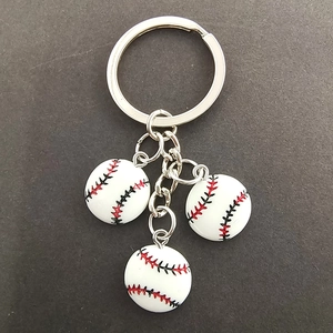 Detail of three miniature baseball pendants with fine stitching and silver keychains