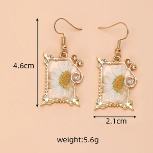Detail view of white dried daisy resin earrings with size 4.6cm and weight 5.6g