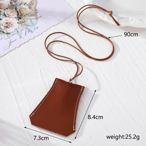 Détail d'un étui à clés en cuir marron en forme de cloche avec coutures blanches et tailles