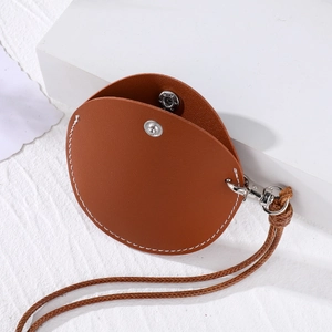 Round brown leather sunglasses case and neck pouch with white stitching and silver snap
