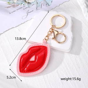 Detailed view of red and pink leather lip-shaped keychain with gold metal hardware