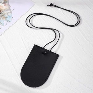 Close-up of minimalist black PU leather key pouch with snap button and long neck strap