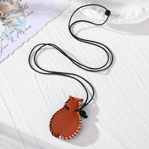Brown leather pouch necklace with hand-stitched details and adjustable black cord