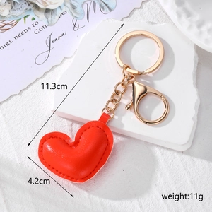 Detail of red faux leather heart keychain with golden chain and dimension markings