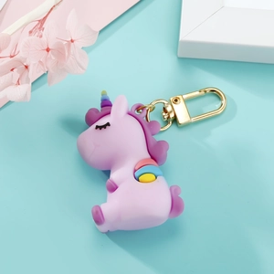 Gros plan d'un porte-clés licorne violet en résine avec crochet doré sur fond bleu