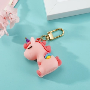 Détail d'un porte-clés licorne rose avec mousqueton doré et détails arc-en-ciel colorés