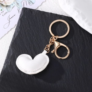 Minimalist white PU leather heart keychain with premium gold lobster clasp on black stone