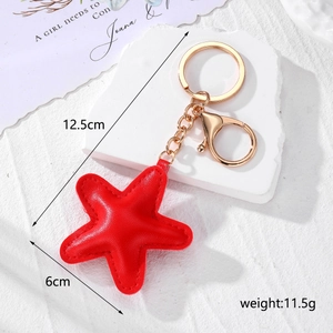Detail view of red star leather keychain with gold lobster clasp and size dimensions