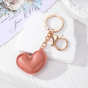 Detail of pink leather heart keychain with neat stitching and gold lobster clasp