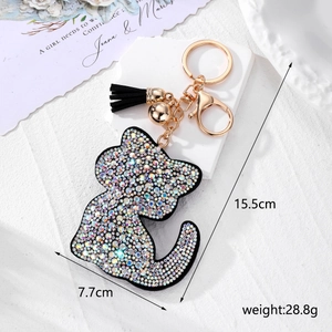 Détail d'un joli porte-clés chat en cuir avec strass colorés, clochette et pompon noir