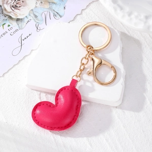 Detail of rose pink heart leather keychain with gold lobster clasp and lychee texture
