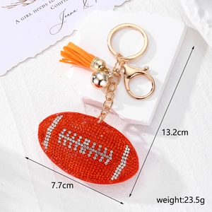 Détail du porte-clés football américain en strass orange avec pompon et anneau doré