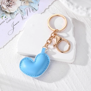 Minimalist light blue leather heart keychain with gold hardware and plush stitching detail
