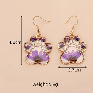 Macro view showing dimensions of cat paw resin earrings with purple dried flowers