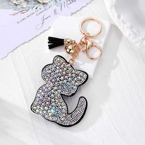 Détail d'un porte-clés chat avec strass noirs, fermoir doré et pompon en cuir élégant
