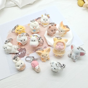 Detailed view of assorted flocked animal keychains including dogs and foxes on a white desk