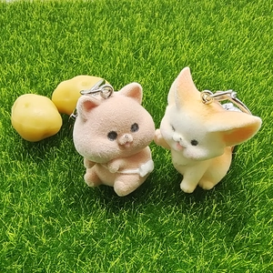 Cute flocked animal keychains featuring a pink cat and orange fox on green grass