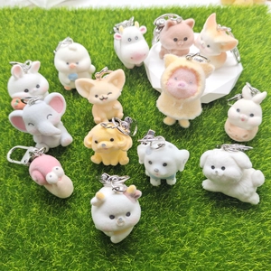 Cute flocked animal keychains featuring elephants and rabbits on a green lawn