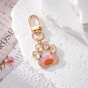 Cat paw keychain with real pink dried flowers in resin, features a gold metal hook