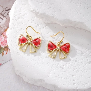 Exquisite gold bow earrings featuring red dried flowers in resin with sparkling zircon