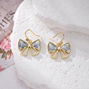Exquisite gold bow earrings featuring blue dried flowers and forget-me-not resin drop style