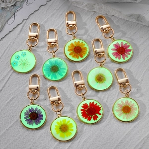 Luminous round resin keychains with real dried daisy and sunflower petals in nine colors