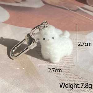 Detail shot of mini plush sheep keychain with soft white fur and silver metal hook clasp
