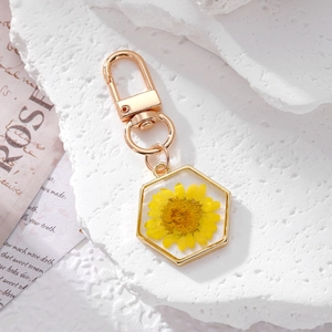 Hexagonal keychain with yellow daisy dried flower in resin and gold metal frame
