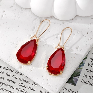 Elegant red teardrop crystal drop earrings with golden hooks on white stone background
