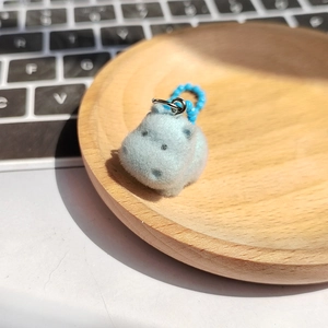 Détail d'un porte-clés hippopotame floqué bleu clair avec chaîne à perles bleue