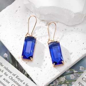 Détail macro de boucles d'oreilles en cristal bleu avec montures dorées élégantes