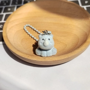 Détail du porte-clés rhinocéros bleu clair avec texture floquée et chaîne à billes argentée