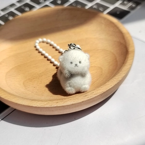 Détail macro d'un joli porte-clés animal floqué blanc sur un plateau en bois naturel