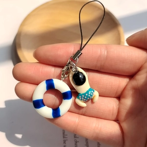 Detail of cute mini swimmer and blue lifebuoy pendant on a durable phone charm strap