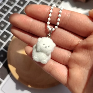 Gros plan d'un mignon porte-clés animal floqué blanc avec anneau et chaîne argentés