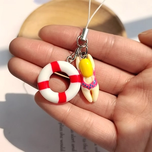 Macro shot of a mini summer swimmer and lifering pendant on a white phone strap
