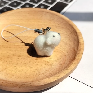 Detail of white flocked animal keychain with soft texture and silver metal clip