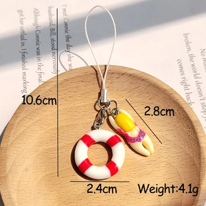 Detailed view of mini summer swimmer keychain with life buoy and swimsuit pendant on wood