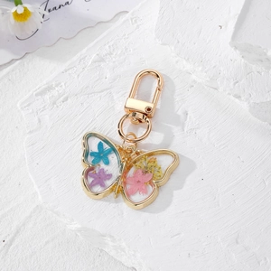 Bohemian butterfly keychain with colorful dried flowers in transparent resin gold frame