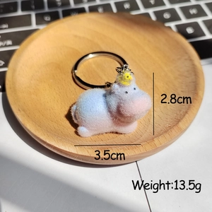 Gros plan d'un porte-clés hippopotame floqué rose et bleu avec un petit canard