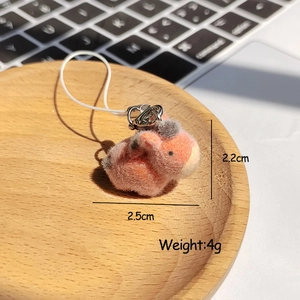 Macro shot of a pink and grey plush animal keychain with metal ring and white cord