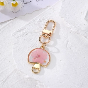 Bohemian mushroom keychain with pink dried flowers in gold metal and resin frame