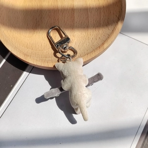 Gros plan d'un porte-clés chat blanc floqué avec une texture douce sur bois