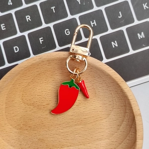 Macro view of 3D alloy red chili keychain with green leaves and gold-plated lobster clasp