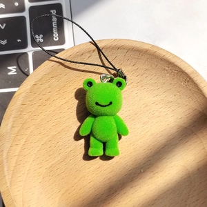 Porte-clés grenouille verte mignonne avec texture velours sur un plateau en bois