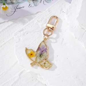 Luminous butterfly keychain with real dried daisy flowers in clear resin and gold frame