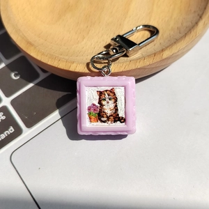 Gros plan d'un porte-clés cadre photo chat mauve sur un clavier d'ordinateur portable