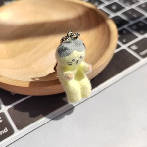 Détail du porte-clés chat jaune floqué montrant la texture douce et l'anneau en métal