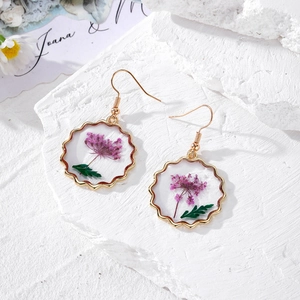 Vintage gold wavy earrings with purple dried flowers in clear resin on stone